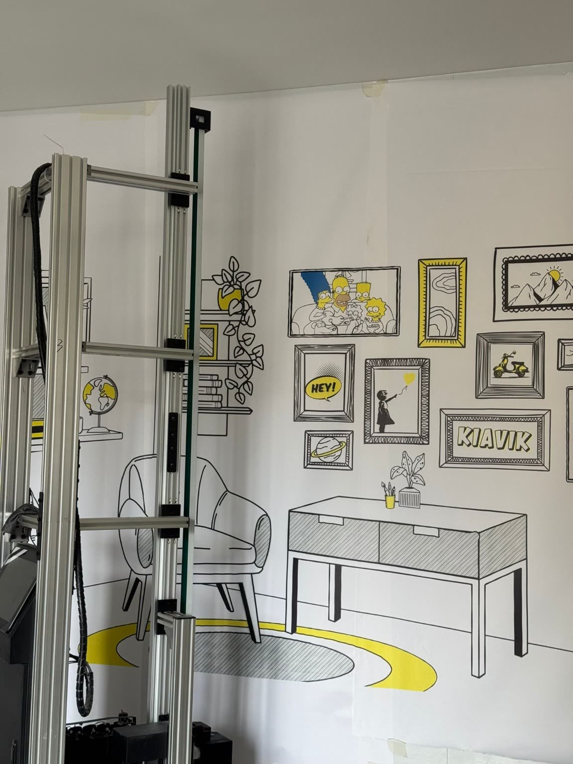 Détail d'un décor imprimé au mur représentant des cadres et un mobilier dessinés au trait